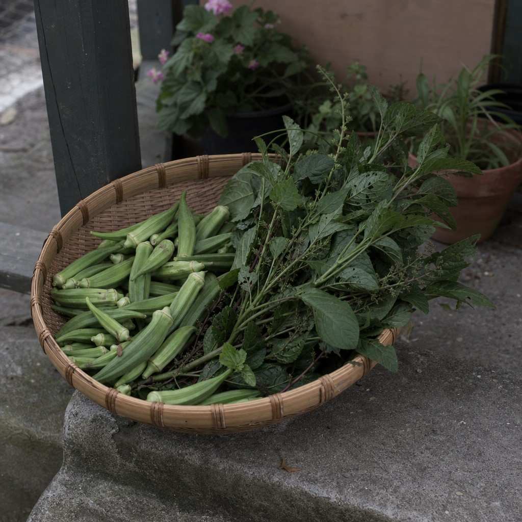 a shallow basket of just-picked okra and summer greens on a shaded step